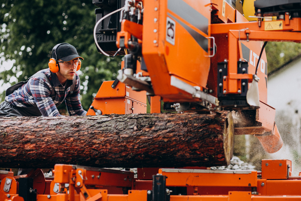 A lumberjack operating a sawmill machine on a log.